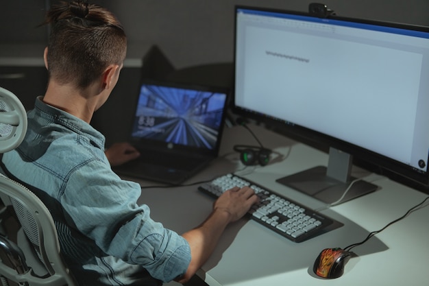 Young male IT industry freelancer working late at night