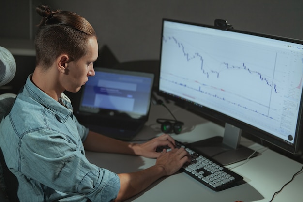 Young male IT industry freelancer working late at night