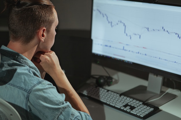 Young male IT industry freelancer working late at night