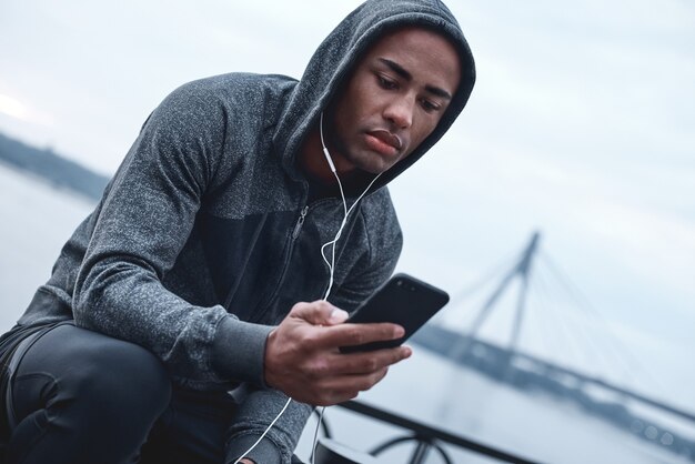 Young male jogger athlete training and doing workout outdoors in