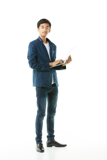 Photo young male junior high school student 15 years old asian young man in casual clothes holding a laptop computer for studying and searching