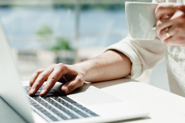 A young male millennial works remotely on a laptop. 