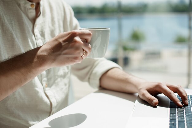 A young male millennial works remotely on a laptop. 