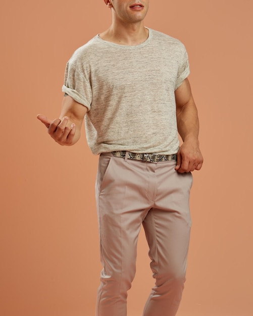 Young male model with casual clothes dancing slowly in front of a brown background