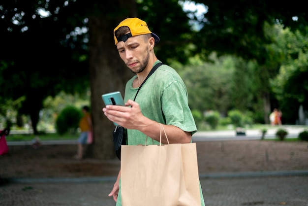 A young male person move in the city with a paper bag, products\
delivery