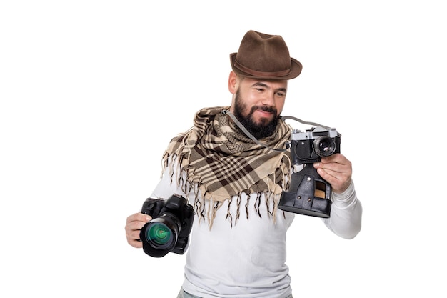 Фото Молодой фотограф-мужчина выбирает между ретро-камерой и цифровой камерой на белом фоне