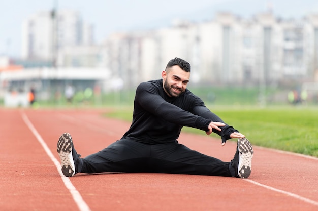 走る前にウォーミングアップする若い男性ランナー