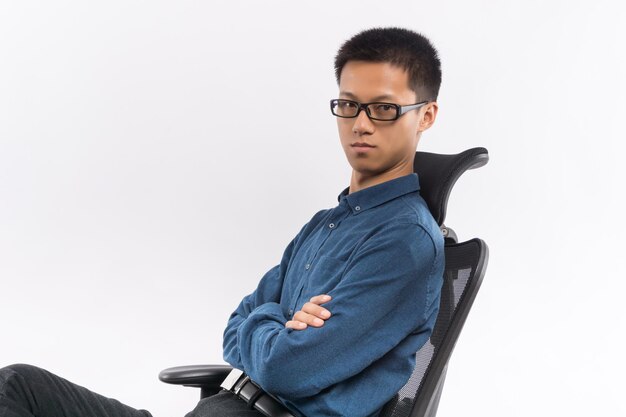 Young male sitting in a chair in front of white background