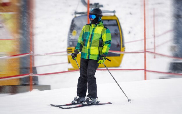 吹雪で斜面を下る若い男性スキーヤー