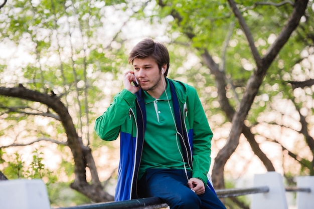 Young male student sitting in the park