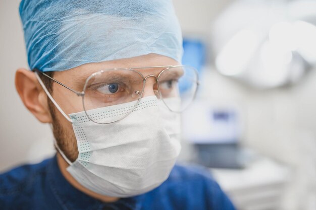 young male surgeon in uniform operates in the operating room of the hospital