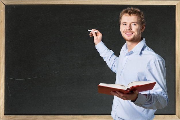 Young male teacher   standing with book