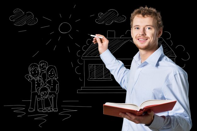 Young male teacher   standing with book