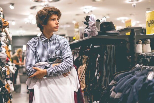 Young male teenager in casual vintage clothes store portrait