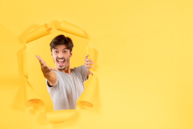 young male on torn yellow paper background indoor facial guy