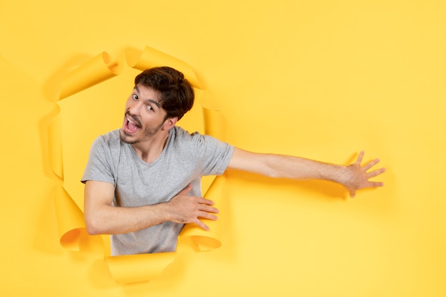 young male on a torn yellow paper background indoor guy handsome facial