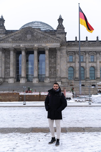 Young male tourist in front of the German Parliament on his sightseeing tour in Berlin Germany