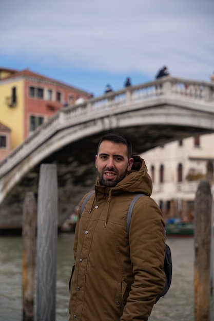 Young male tourist looking towards the canals of Venice with gondolas