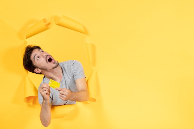 young male with credit card on yellow surface money shopping sale bank