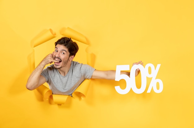 Young male with inscription sign on torn yellow desk sale shopping indoor guy