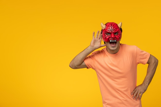 Young male with scary devil mask yellow background cartoon young