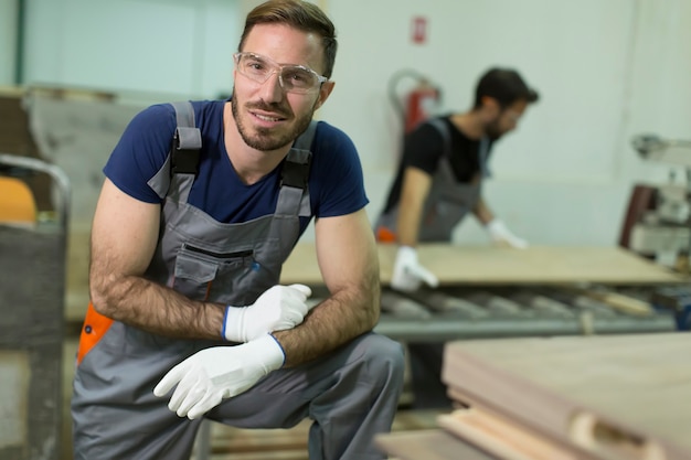 Young male workers work in a factory for the production of furniture