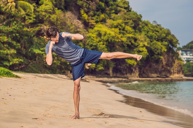 Young male working out on beach, sporty man doing exercises