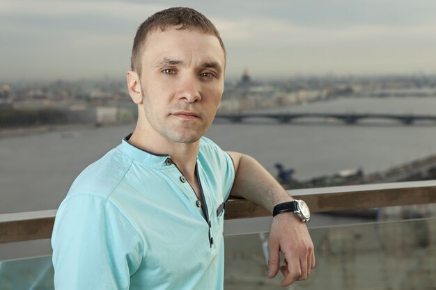 A young man 27 years old, Caucasian, Slav, Russian, dressed in turquoise shirt with short sleeves.