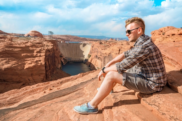 A young man admires the amazing view of Glen Canyon Dam and the Colorado River in Page Arizona