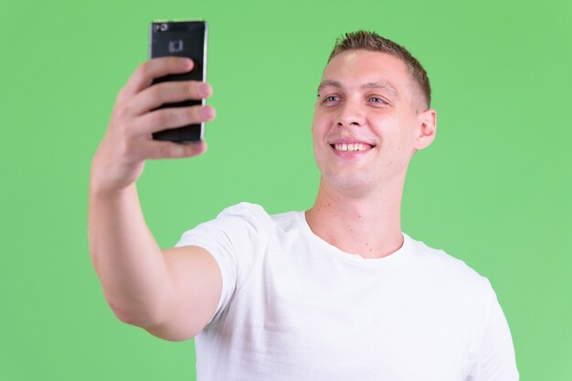  young man against green wall