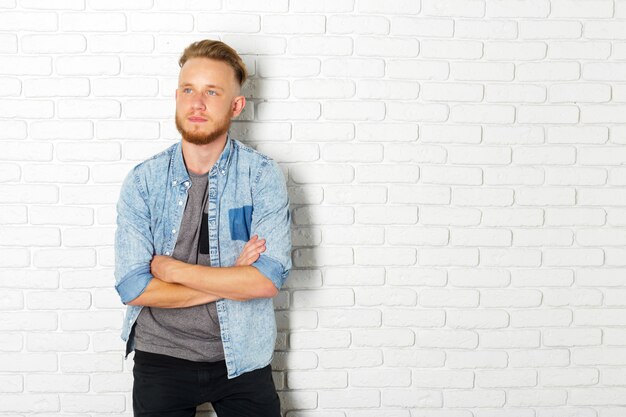 Young Man Against a White Brick Wall