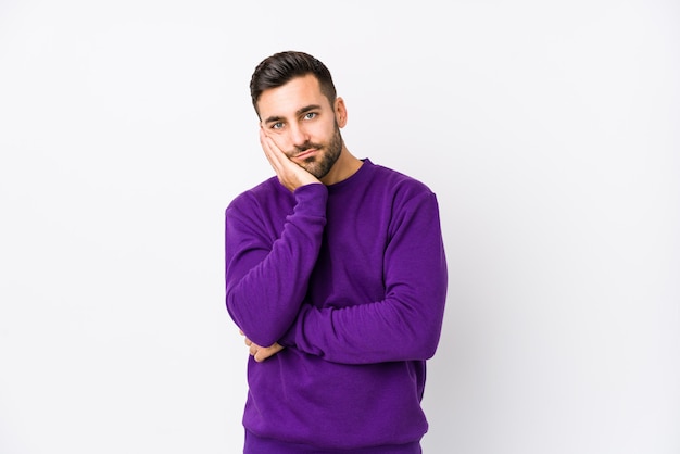 Young man against a white wall isolated who is bored, fatigued and need a relax day