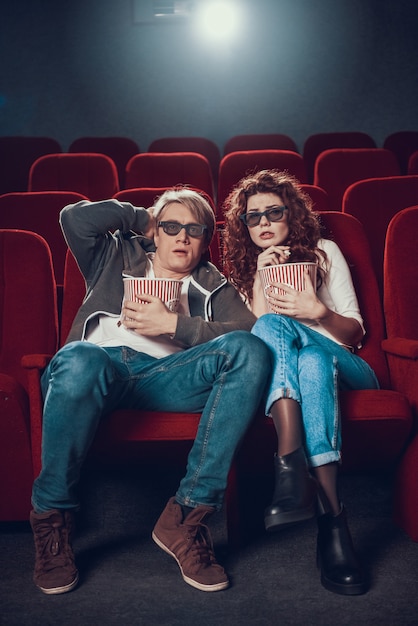 사진 젊은 남자와 여자는 공포 영화를보고있다