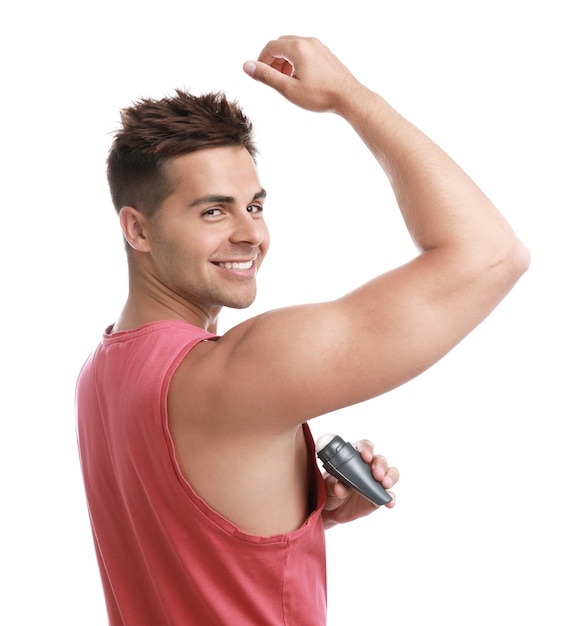 Photo young man applying deodorant to armpit on white background