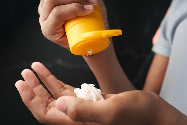 Young man applying sunscreen cream