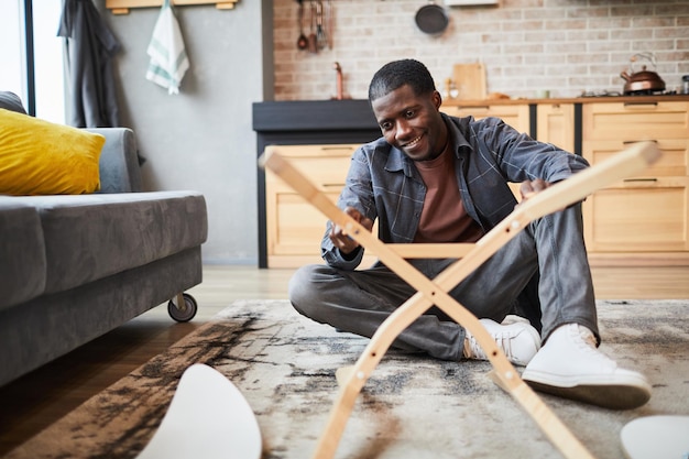 Young Man Assembling Furniture at Home