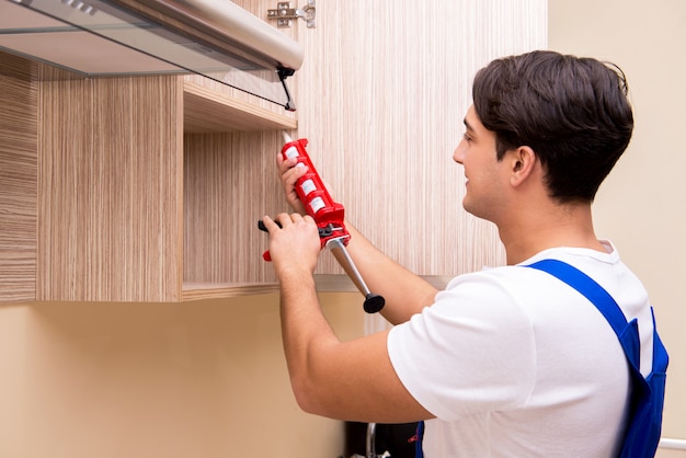 Young man assembling kitchen furniture