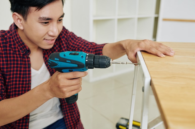 Young man assembling table