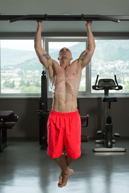 Young Man Athlete Doing Pull Ups ChinUps In The Gym