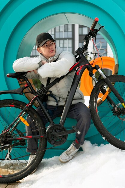 A young man in autumn clothes sat down to rest after a bike ride