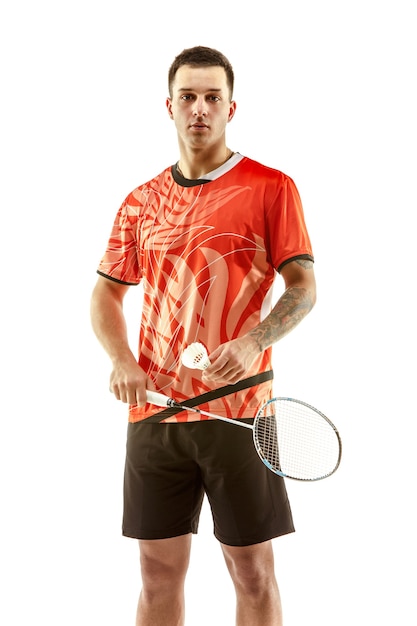 Young man badminton player standing over white studio background. Fit male athlete