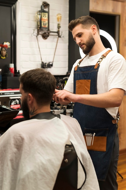 Foto giovane dal barbiere che si fa tagliare i capelli