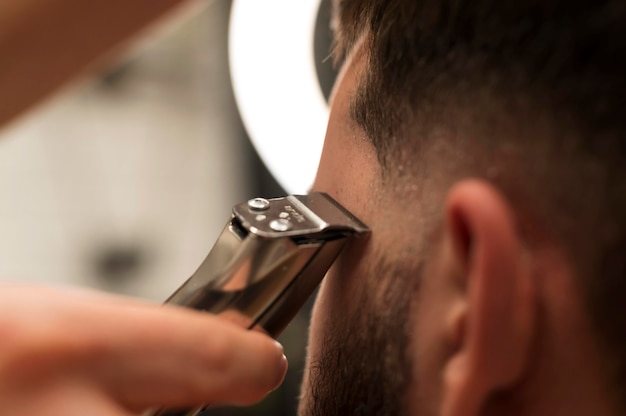 Foto giovane dal barbiere che si fa tagliare i capelli