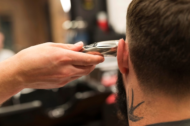 Foto giovane dal barbiere che si fa tagliare i capelli