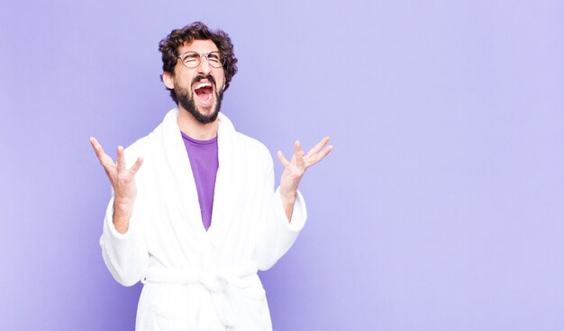 Young man in a bathrobe furiously screaming