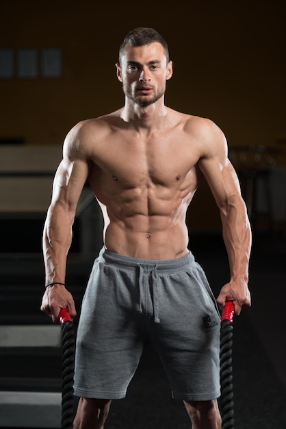 Young Man Battling Ropes At Gym Workout Exercise