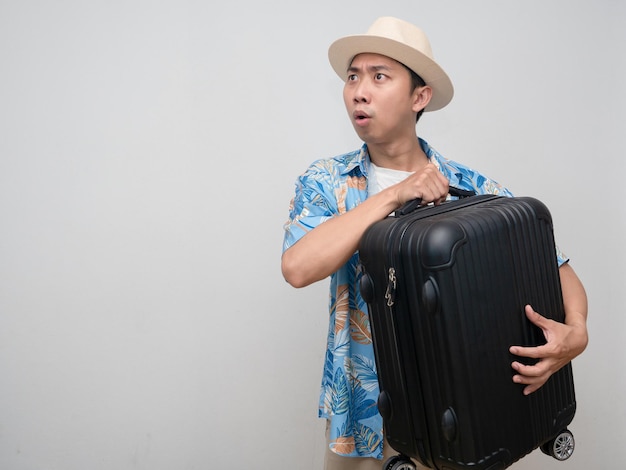 Young man beach shirt wear hat hold luggage feels amazed isolated