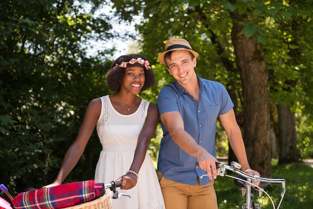 a young man and a beautiful African American girl enjoying a bike ride in nature on a sunny summer day