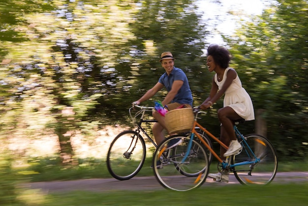 a young man and a beautiful African American girl enjoying a bike ride in nature on a sunny summer day