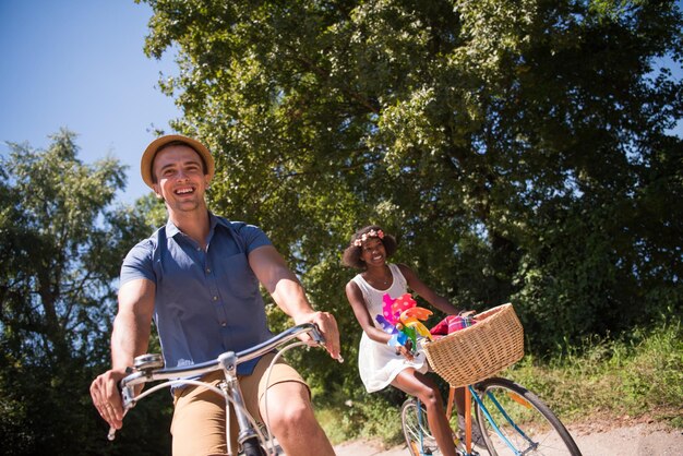 a young man and a beautiful African American girl enjoying a bike ride in nature on a sunny summer day